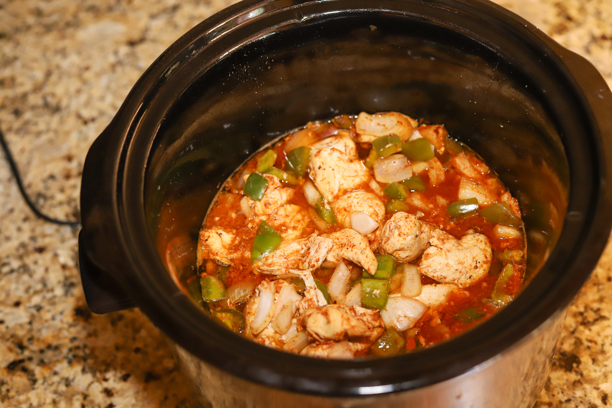 A crock pot full of chicken fajita on a kitchen counter