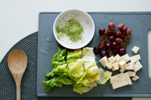 Dates, tofu, and lettuce on gray chopping board