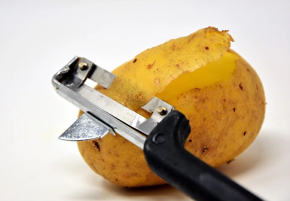 peeling a potato using a Lancashire peeler
