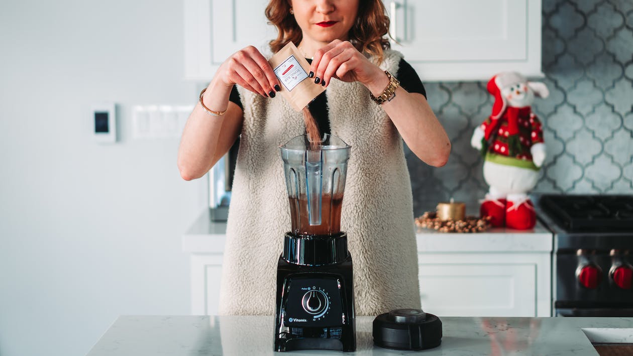Woman-pouring-power-on-the-mixer-grinder