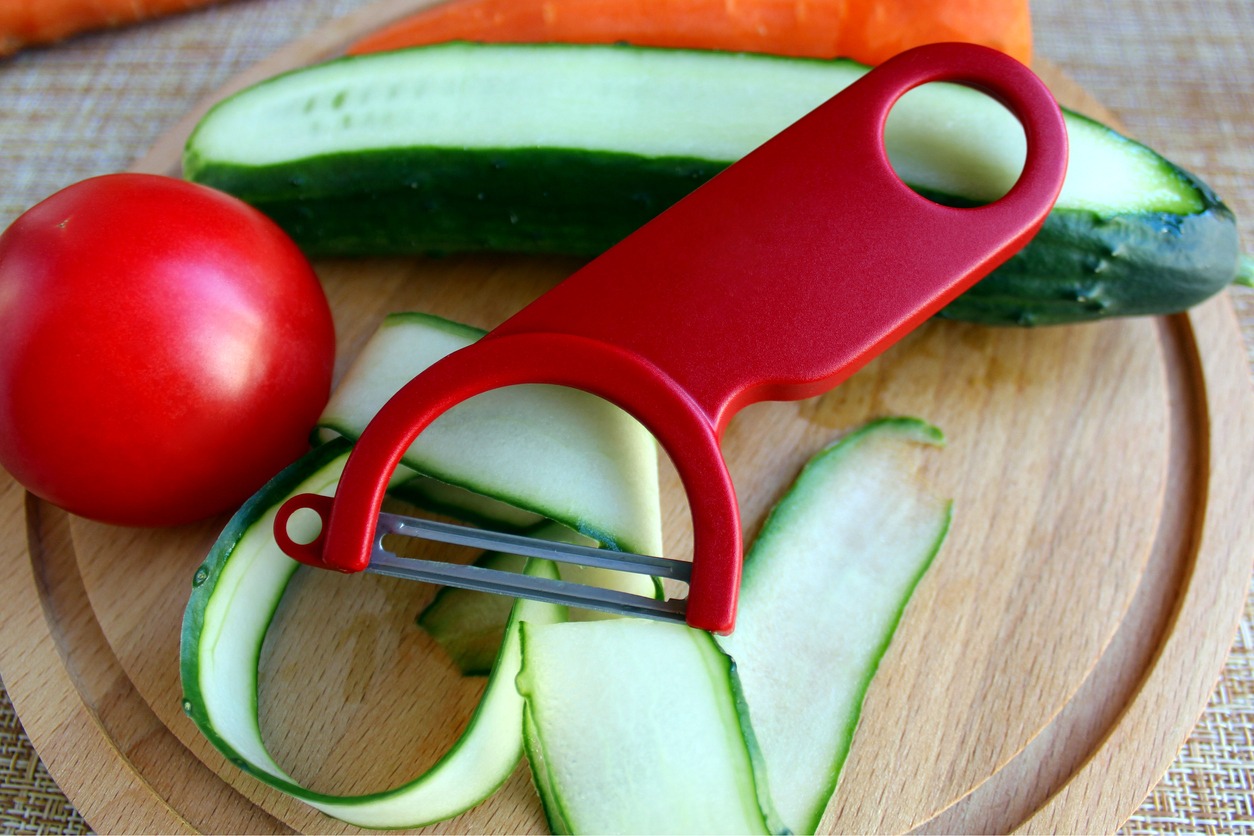 a red peeler on a fresh cucumber